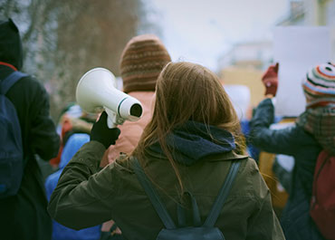California employment protections for political protesters—image of a demonstration with a megaphone.