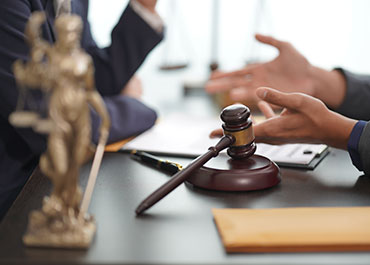Legal discussion on Proposition 22 litigation—gavel and attorney hands in negotiation.